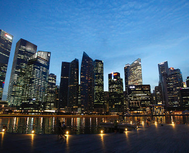 People walk past the skyline of Marina Bay central business district in Singapore April 26, 2013